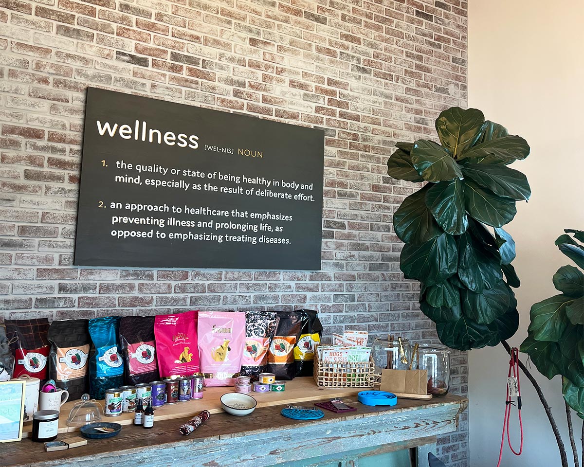 black decorative sign on interior brick wall with the definition of wellness