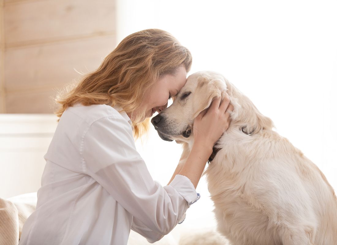Woman and dog forehead-to-forehead