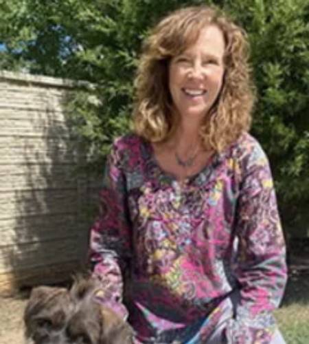Smiling woman and small dog.
